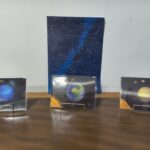 Blue constellation map poster on a wall, with star patterns and labeled figures, flanked by planetary images below.